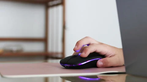 Macro view of a childs fingers operating a glowing gaming mouse. Stock Footage 310218134