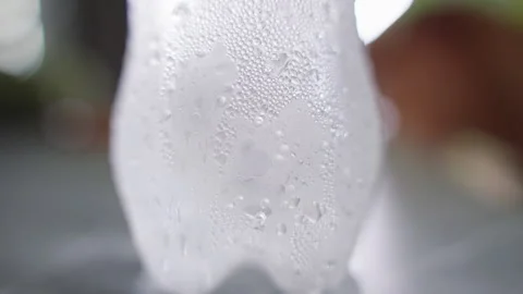 Macro View of Cold Plastic Bottle Slowly Rotating While Covered With Water Conde Stock Footage 339200258