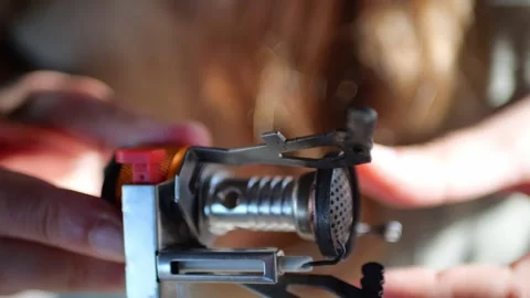 Macro view of compact camping stove burner in woman hands... Stockbeeldmateriaal 322811571