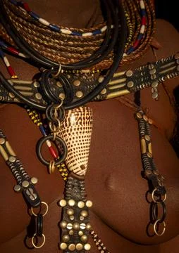 Macro view of a cowrie shell pendant hanging among beaded necklaces and bra.. Foto stock