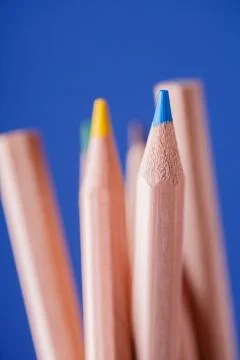 Macro view of crayons. Colored Pencils. Colored pencils on blue background. Stock Photos
