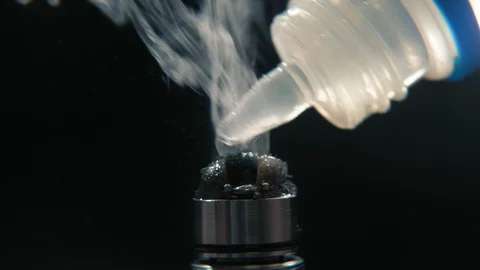Macro view of dripping coil in RTA vape device in slowmotion on black background Stock Footage 103112126