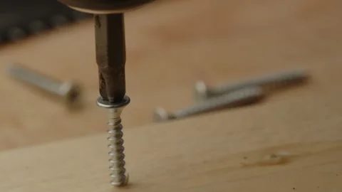 Macro view of electric screwdriver drilling screw in wooden board on a Stock Footage 261129169