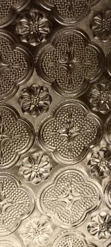 Macro view of embossed glass surface with floral and clover motifs. Foto stock