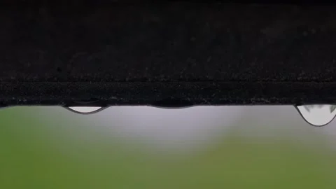 Macro view of falling raindrops from  window frame of skylight during rain. Stock Footage 197060695