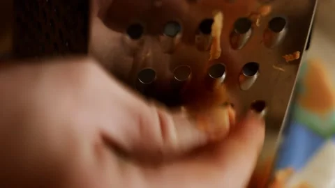 Macro view of female hand rubbing carrots on a grater in the home kitchen. 4K Stock Footage 144902518