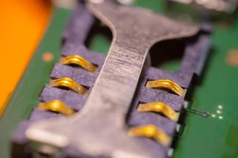 Macro view of gold electrical contacts on a green circuit board beneath a d.. Foto stock