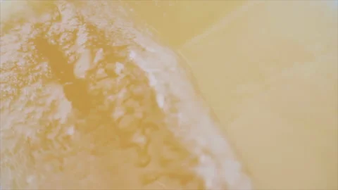 Macro View of Golden Beer Sloshing and Foaming Stock Footage 344251612