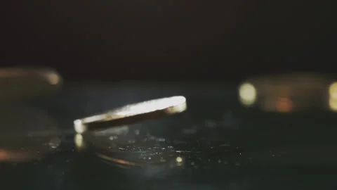 Macro view of golden bitcoin coins spinning on dark reflective glass surface. Stock Footage 337602175