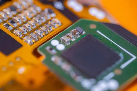 Macro view of green circuit board with black microchip, silver electronic c.. Stock Photos