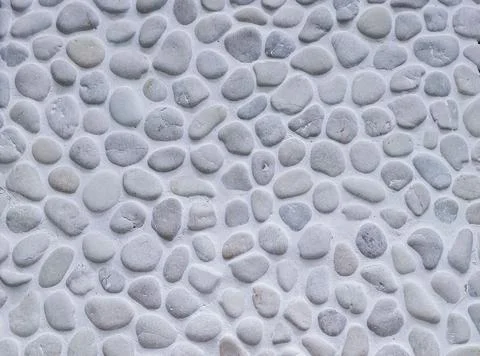 Macro view of grey river pebbles set in light mortar on a stone floor for s.. Stock Photos