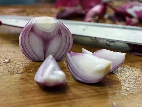 A macro view of a halved red onion and fresh wedges showing the internal layers Stock Photos