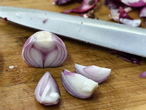 A macro view of a halved red onion and fresh wedges showing the internal layers Stock Photos