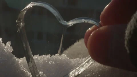 Macro View of Hand Adjusting Frozen Soap Crystal Heart on Snow Видео 331167483
