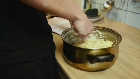 Macro view of hands mixing raw dough in saucepan Stock Footage 340078051