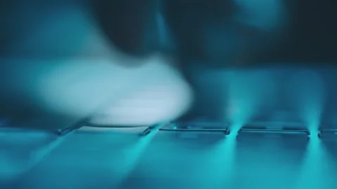 Macro view of hands typing fast on laptop keyboard with blue backlight in d.. Stock Footage 337472133