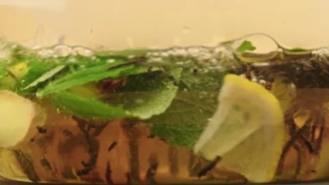 Macro view herbal tea infusion of mint, ginger, lemon, black tea leaves Stock Footage 318891518