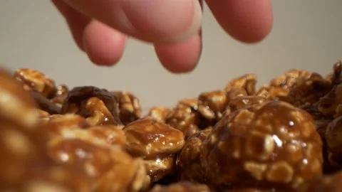 Macro view how woman's hand takes popcorn. Caramel popcorns in the bowl. Probe Stock Footage 133180675