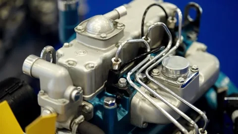 Macro view of an industrial engine assembly with polished metal fuel lines Stock Footage 325671156