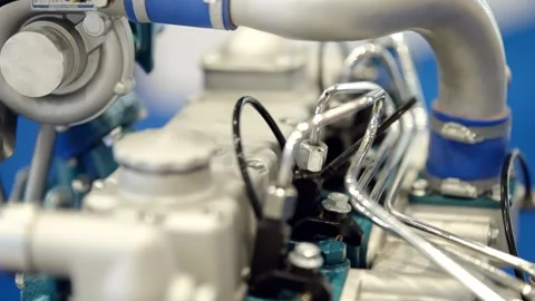 Macro view of an industrial engine assembly with metallic pipes, valves, and Stock Footage 325671467