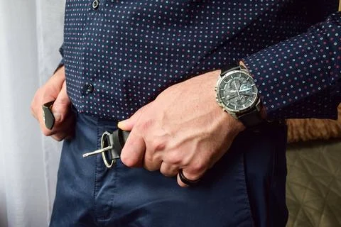 Macro view of a man's hands fastening a black leather watch strap Stock Photos