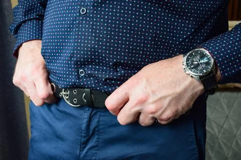 Macro view of a man's hands fastening a black leather watch strap Stock Photos