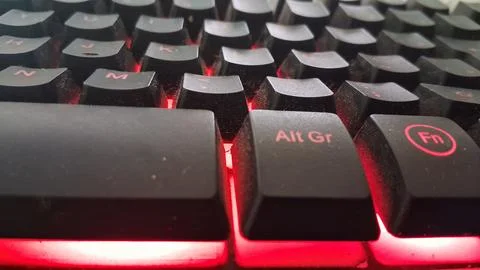 Macro view of a mechanical gaming keyboard with glowing red illumination Stock Photos