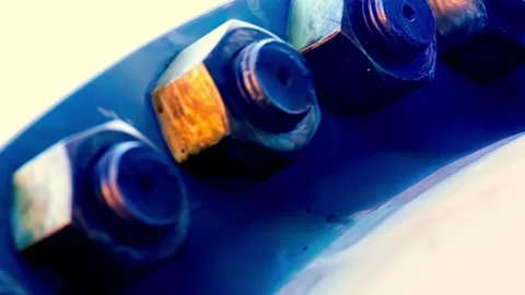 Macro view of metal bolts and nuts fixed on blue industrial metal surface Stock Footage 332145017