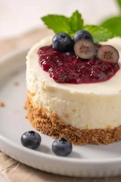 Macro view of a mini cheesecake with glossy berry compote and fresh mint Stock Photos