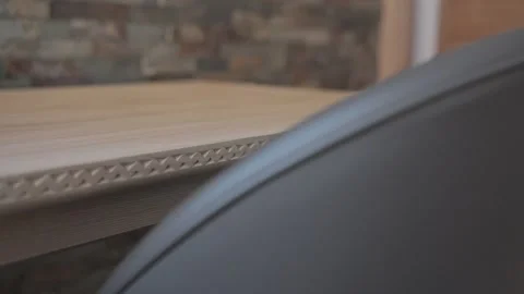 Macro view of a modern dark gray leather chair backrest next to a carved wooden Stock-Footage 334712989