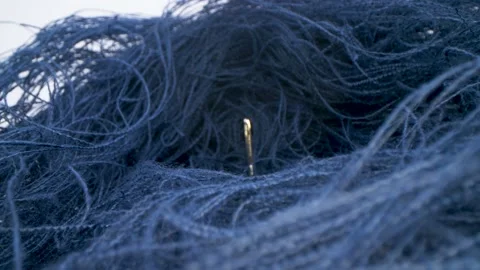 Macro view of needle surrounded by threads. Needle in a haystack. Moving shot. Stock Footage 152794102