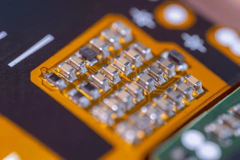 Macro view of orange printed circuit board with metallic electronic compone.. Stock Photos