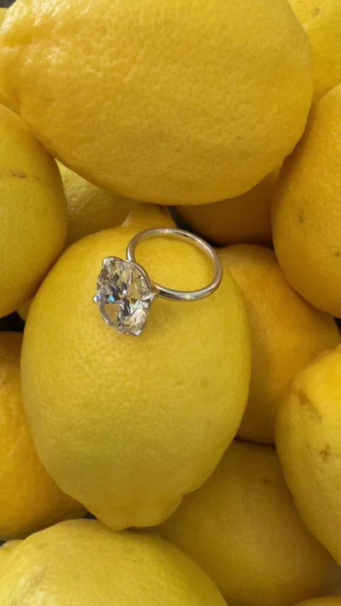 Macro view of oval diamond engagement ring on vibrant lemons Stock Footage 320313892