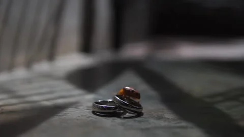 Macro View of Pair of Gold Wedding Bands and Engagement Ring Stock Footage 341009433