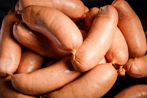 Macro view pile of short thick wieners rolled in spiral on scales 写真素材