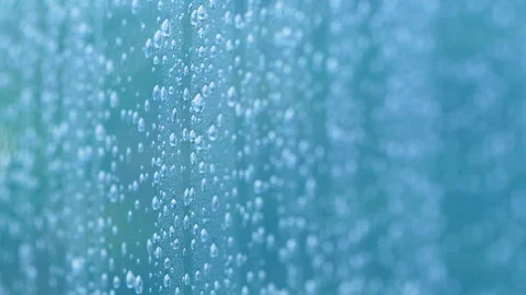 Macro View Of Rain Drops On Glass Surface With Blue Bokeh Stock Footage 345446072