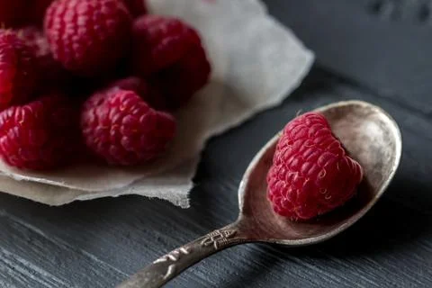 Macro view for raspberry in the tea spoon and raspberry pile on the background Stock Photos
