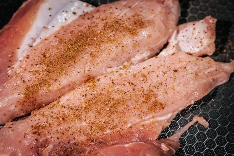 Macro view of raw chicken fillets coated with ground spices . Foto stock