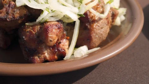 Macro view: Ready juicy kebab seasoned with fresh onions. 4k Видео 104061379