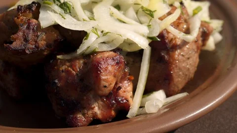 Macro view: Ready juicy kebab seasoned with fresh onions. 4k Видео 104063544