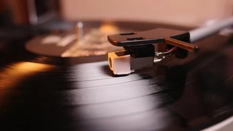 Macro view of record player cartridge and stylus tracking grooves on a spin.. Stock Photos