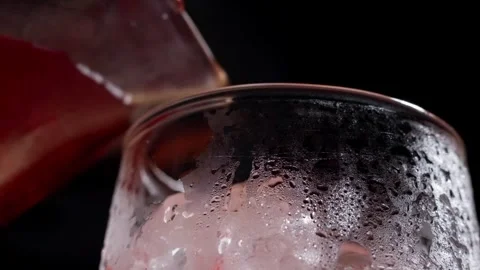 Macro View of Red Cocktail Pouring into Frosted Glass with Condensation Stock Footage 337862630
