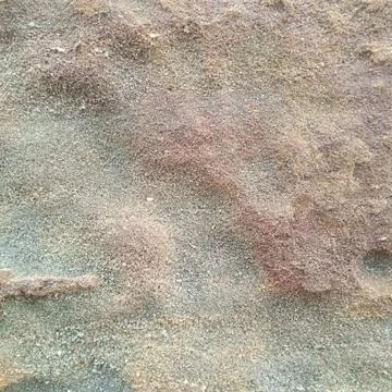 Macro view of reddish brown sandy rock surface texture grains earthy Stock Photos