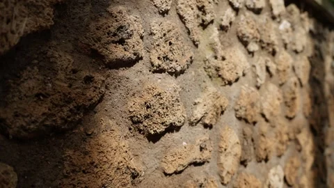 Macro view of rough Pompeii wall texture in warm sunlight, highlighting porous Stock Footage 335371794