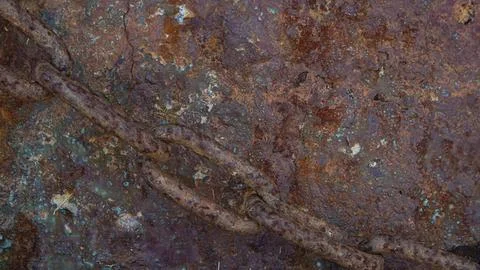 Macro view of rusted iron surface intersected by a corroded chain at a coas.. Stock Photos