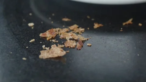 Macro view of scattered brown bread crumbs resting on dark textured kitchen.. Stock Footage 332116470