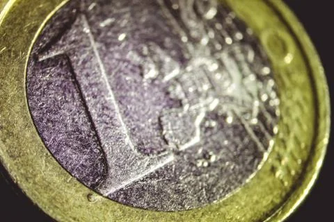 Macro view of the scratched one euro coin in the darkness Stock Photos