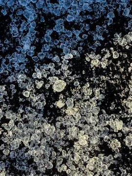 Macro view of sharp ice crystals on a deep black surface. Clearly visible fro Foto stock