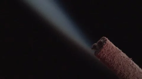 Macro View of Smoldering Incense Stick Releasing Stream of Smoke into Dark Stock Footage 339755750