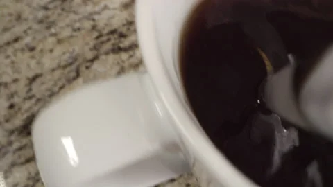 Macro view of spoon stirring a cup of coffee in slow motion 스톡 동영상 189606988